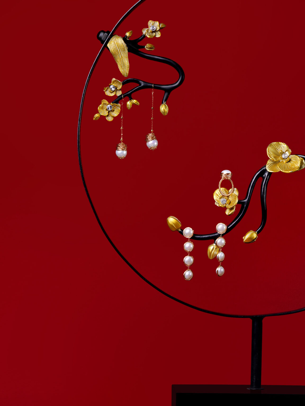 Traditional gold and pearl jewelry set displayed against a deep red background.