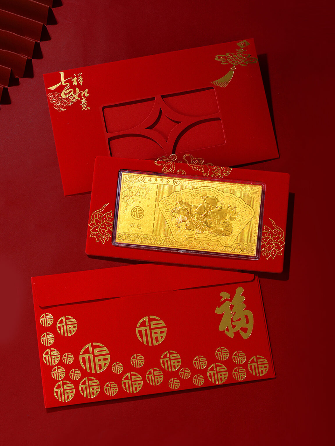 Gold bar and red gift envelopes arranged in a festive Chinese-style product scene.